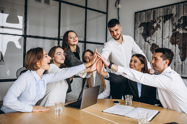 people showing workplace culture by high fiving in a board room around a table
