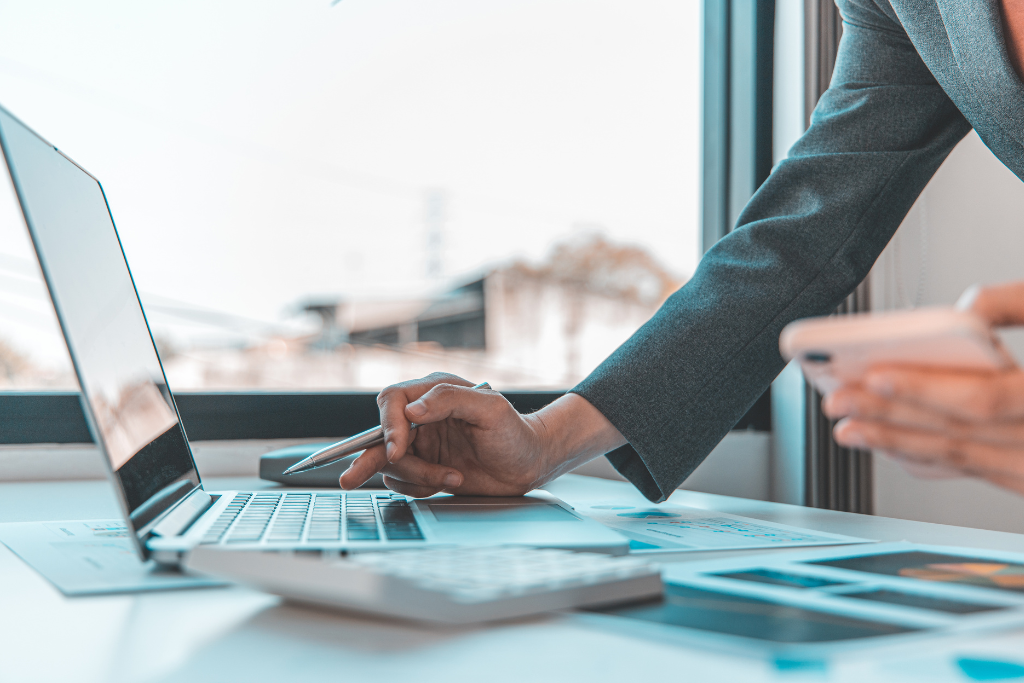 Value Stream Mapping in Operating Model Design showing business professional working on laptop and documents.